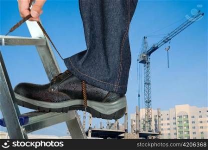 repairman lace his shoes on building background