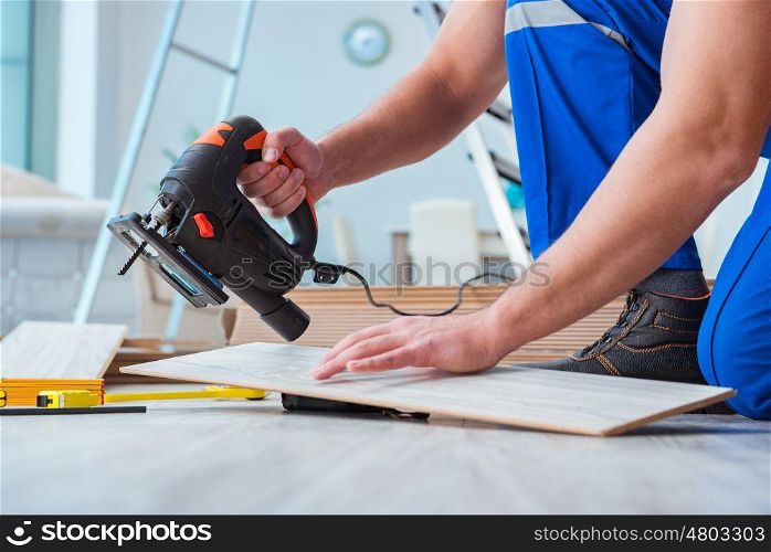 Repairman laying laminate flooring at home