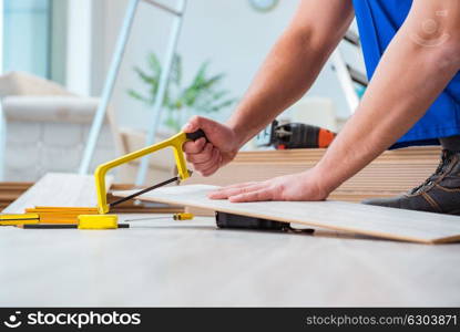 Repairman laying laminate flooring at home