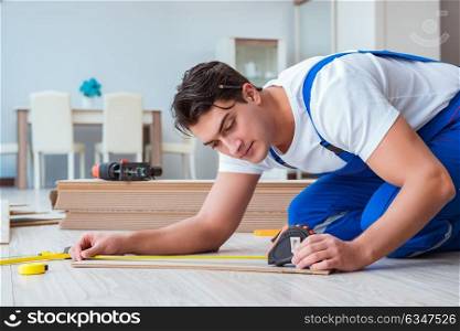 Repairman laying laminate flooring at home