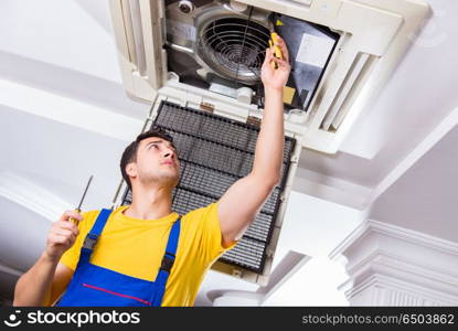 Repairman repairing ceiling air conditioning unit