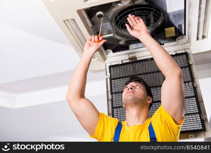 Repairman repairing ceiling air conditioning unit