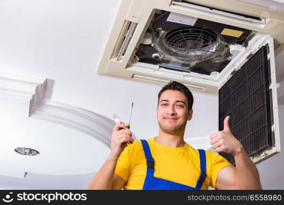 Repairman repairing ceiling air conditioning unit