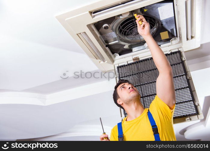 Repairman repairing ceiling air conditioning unit