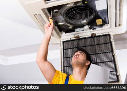 Repairman repairing ceiling air conditioning unit