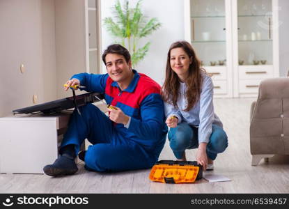 Repairman repairing tv at home