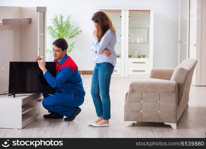 Repairman repairing tv at home