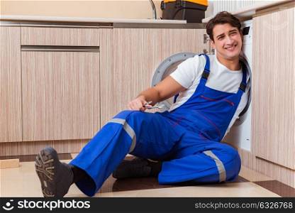 Repairman repairing washing machine at kitchen