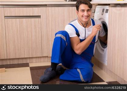 Repairman repairing washing machine at kitchen
