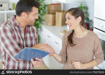 repairman shaking hands with woman