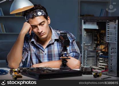 Repairman trying to repair laptop with miscroscope