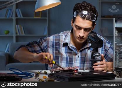 Repairman trying to repair laptop with miscroscope