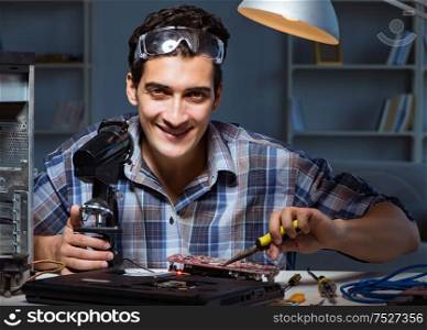 Repairman trying to repair laptop with miscroscope. The repairman trying to repair laptop with miscroscope