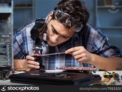 Repairman trying to repair laptop with miscroscope. The repairman trying to repair laptop with miscroscope