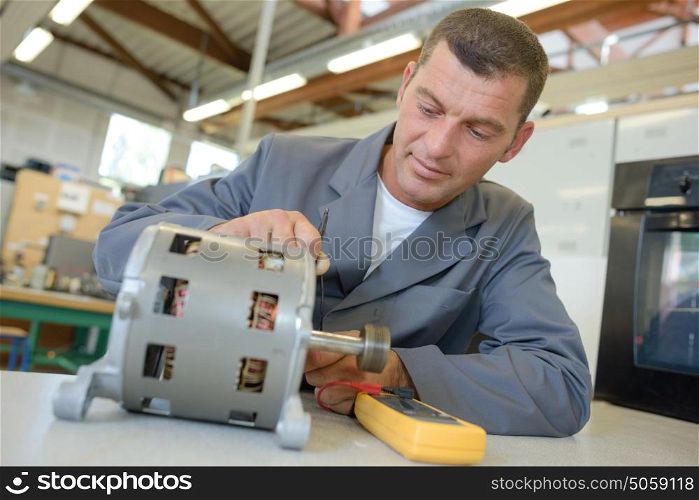 Repairman working on cylindrical electrical component