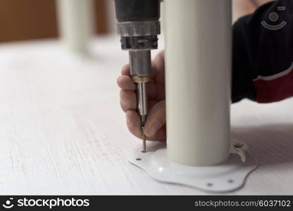 repairman working with drilling machine and assambling furniture