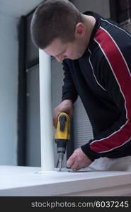 repairman working with drilling machine and assambling furniture