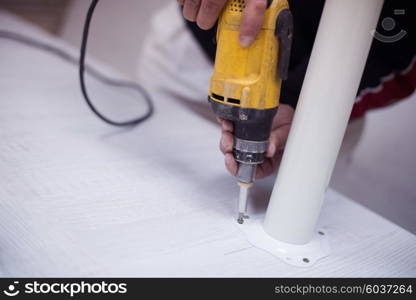 repairman working with drilling machine and assambling furniture