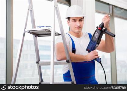 Repairman working with power drill in workshop