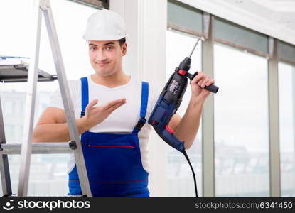 Repairman working with power drill in workshop