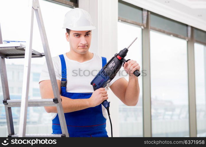 Repairman working with power drill in workshop