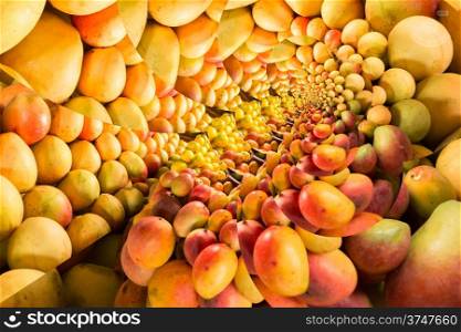 Repeating pattern of a pile of ripe mangos on a fruit stand