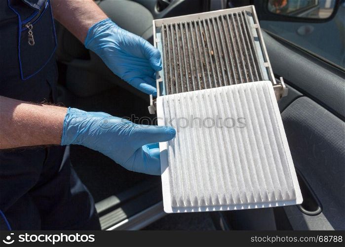 Replacing the pollen air filter. Old and new cabin air filter for a car.