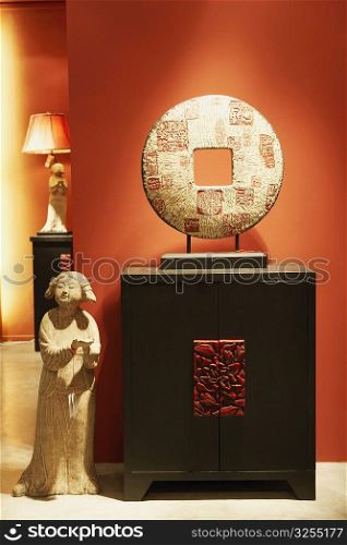 Replica of a traditional Chinese coin and a statue in a furniture store