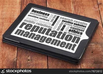 reputation management word cloud on adigital tablet tablet against red wood