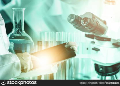 Research and development concept. Double exposure image of scientific and medical lab instrument, microscope, test tube and glass flask for microbiology and chemistry in laboratory for medicine study.