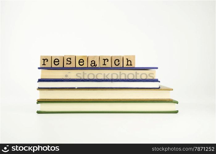 research word on wood stamps stack on books, library and education concept