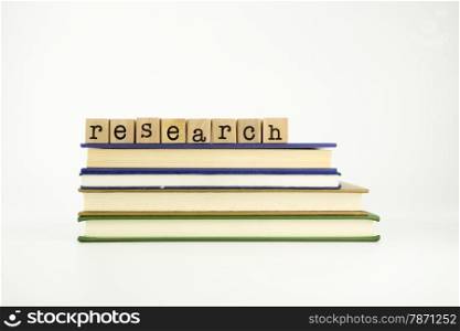 research word on wood stamps stack on books, library and education concept