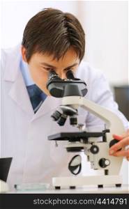 Researcher working with microscope in laboratory