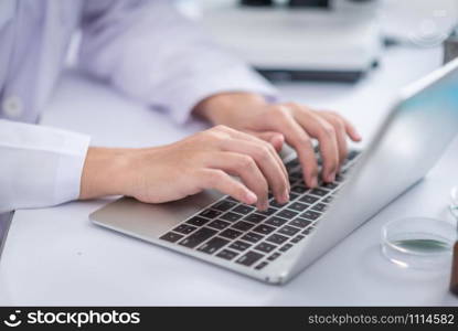 Researchers are analyzing data using a laptop. In the laboratory