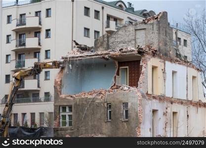 Residential building demolition with excavator