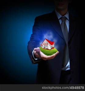 Residential building. Residential building and a businessman holding it in his hands