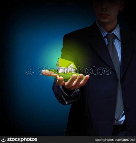 Residential building. Residential building and a businessman holding it in his hands