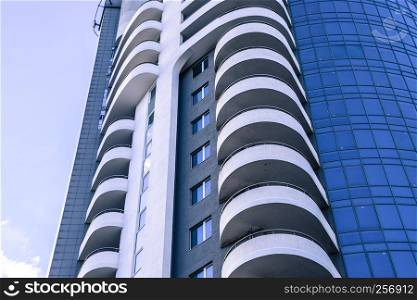 Residential building with balconies, multi-storey building. Building against the blue sky with clouds.. Residential building with balconies, multi-storey building. Building against the blue sky with clouds