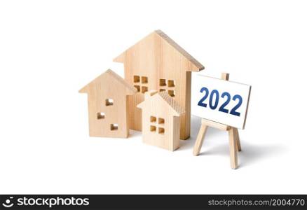 Residential buildings and easel 2022. Concept of real estate market in new year. Housing market predictions, trends and tendencies. Investment plans. Mortgage loan. Economic analysis. Home loans