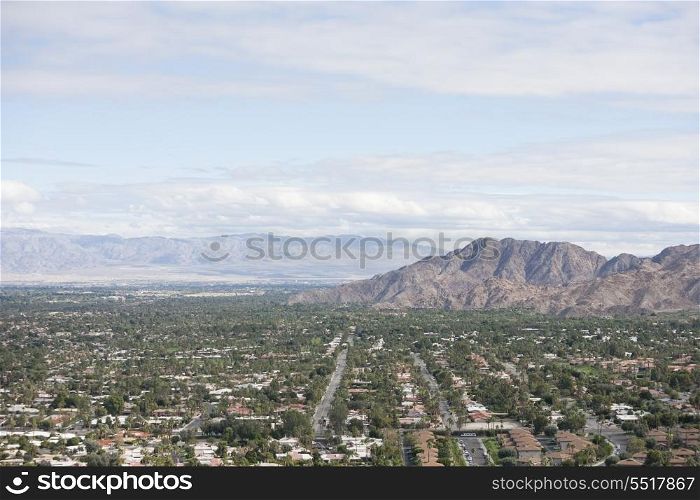 Residential district and mountains against cloudy sky