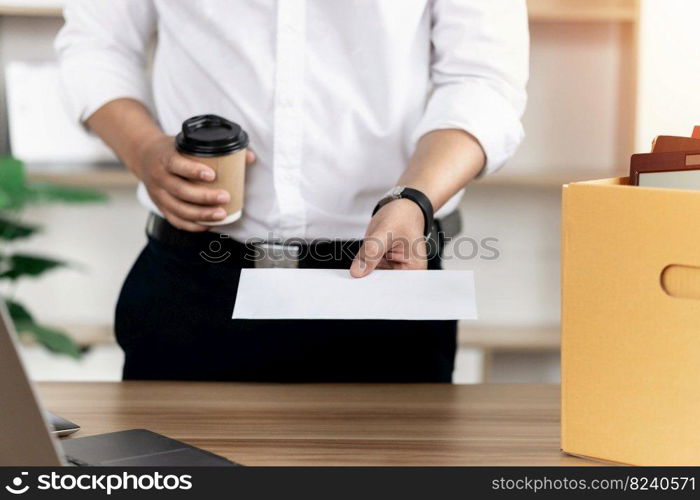 Resignation A businessman puts his personal box on the table and hands his boss a white letter. to quit the job business concept fired or out of work grand resignation