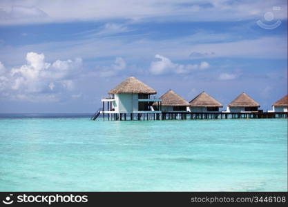 resort maldivian houses in blue sea