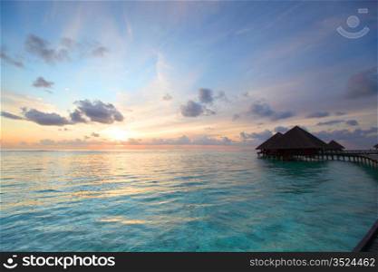 resort maldivian houses on sunrise