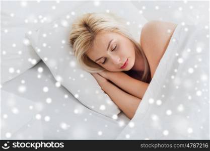 rest, comfort and people concept - young woman sleeping in bed at home over snow. young woman sleeping in bed at home bedroom