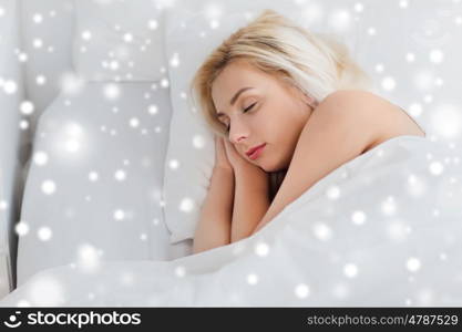 rest, comfort and people concept - young woman sleeping in bed at home over snow