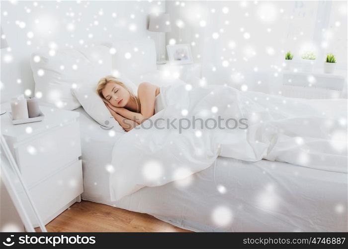 rest, comfort, cosiness and people concept - young woman sleeping in bed at home bedroom over snow