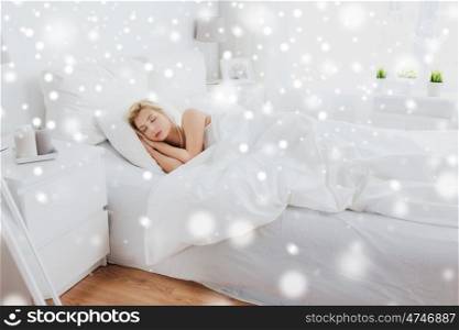 rest, comfort, cosiness and people concept - young woman sleeping in bed at home bedroom over snow