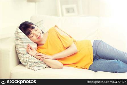 rest, relax and people concept - happy asian teenage girl or young woman sleeping on sofa at home. happy asian teenage girl sleeping on sofa at home. happy asian teenage girl sleeping on sofa at home