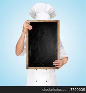 Restaurant chef hiding behind a blank chalkboard for a business lunch menu with prices.