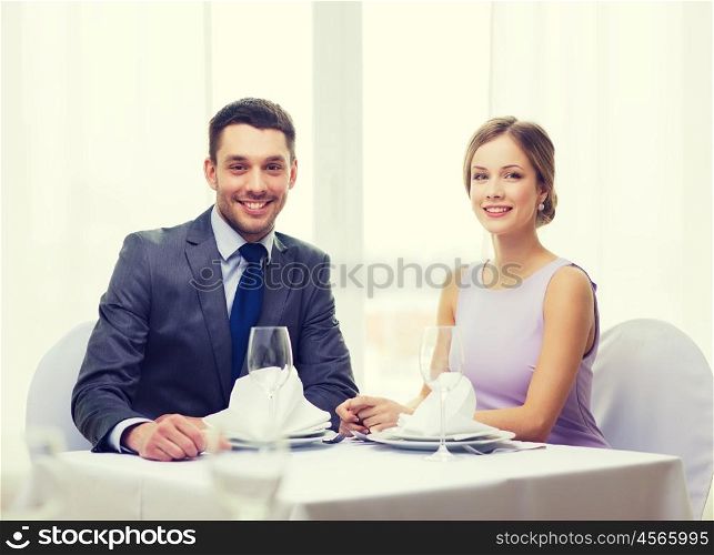 restaurant, couple and holiday concept - smiling couple at restaurant